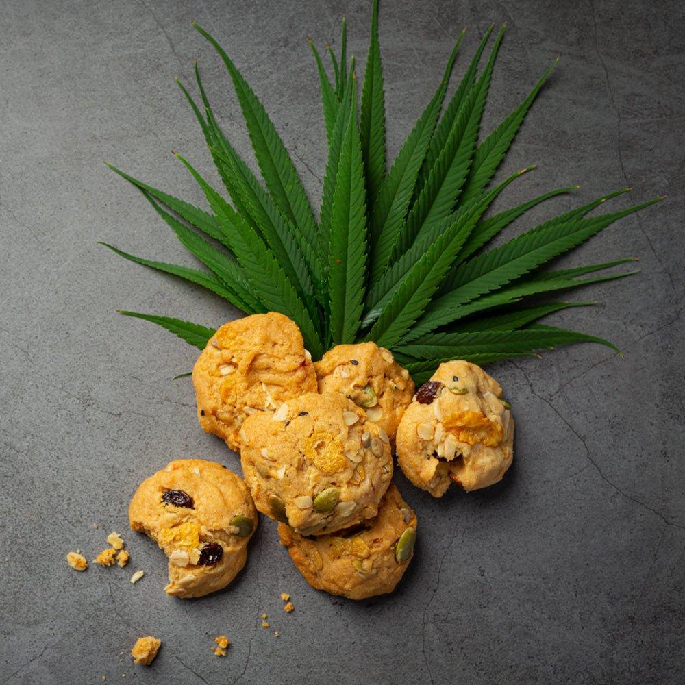 Cannabis leaves with cookies on a gray background.