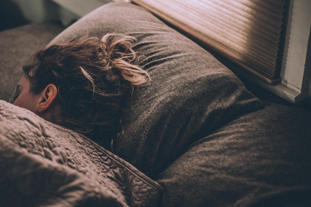 Person sleeping peacefully in a cozy bed.